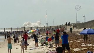 Beach-goers watch the launch of an Atlas V rocket carrying the Orbital ATK Cygnus cargo ship S.S. John Glenn into orbit from Cape Canaveral Air Force Station, Florida in this still from a NASA TV broadcast on April 18, 2017