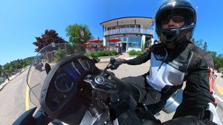 A Honda Goldwing touring motorbike, emphasising the sound system onboard, with a driver in a bike helmet 