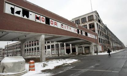 A woman walks next to the abandoned Packard Motor Car Company building, which ceased production in the 1950s, in Detroit on December 18, 2008. 