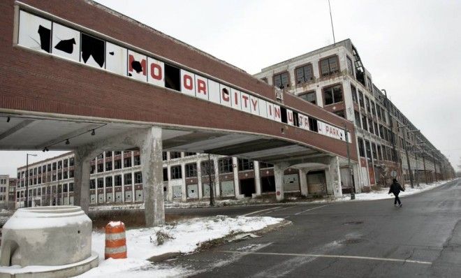 A woman walks next to the abandoned Packard Motor Car Company building, which ceased production in the 1950s, in Detroit on December 18, 2008. 