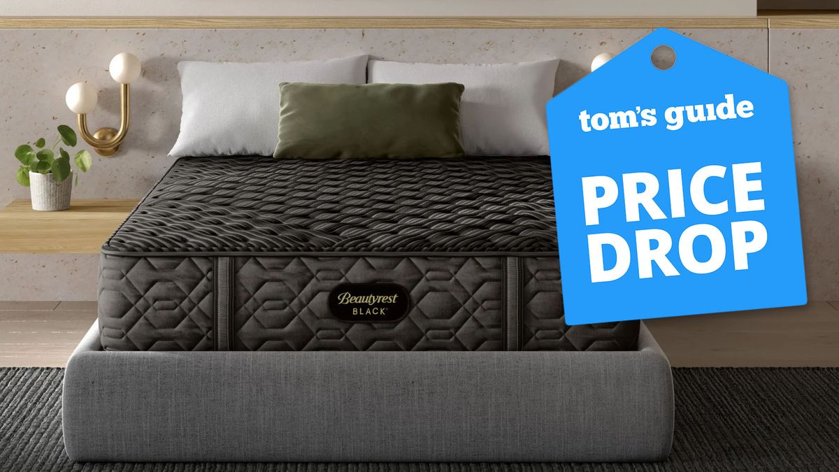 A Beautyrest Black Mattress on a bed frame in a luxury bedroom, a Tom&#039;s Guide price drop deals&#039; graphic (right)