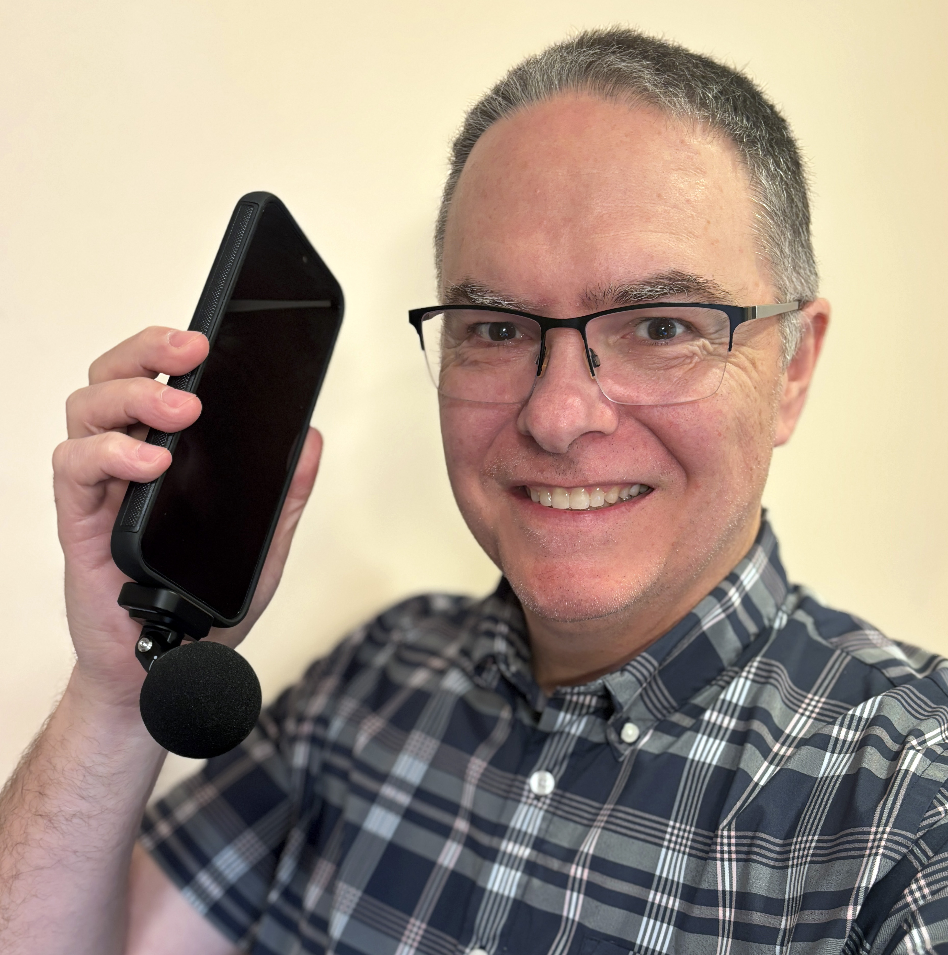 Mark J. Pescatore holding a cell phone with the Shure MV88-USBC attached.