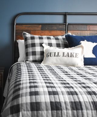 Industrial farmhouse style bed with mono bedlinen and relaxed scatter pillows.