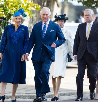 Queen Camilla, The King, Princess Anne, Prince Andrew walking outside in suits and dress coats