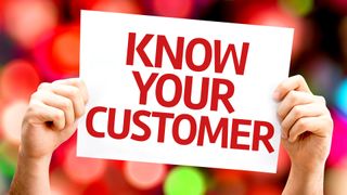 Hands holding up a sign saying 'know your customer' in red letters