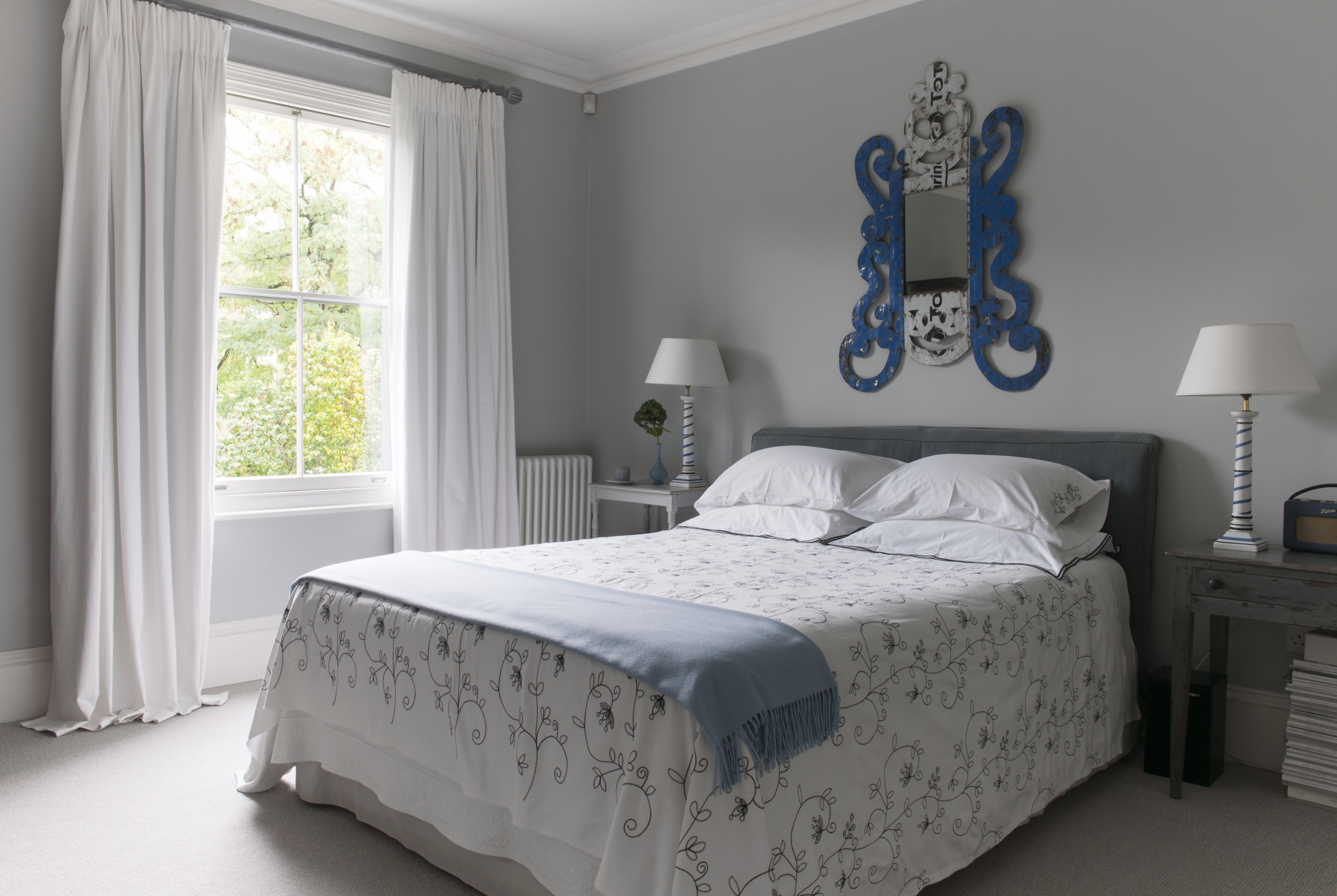 Double bedroom with floor length curtains and neutral decor