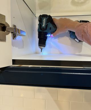 Drilling hole into navy kitchen cabinet