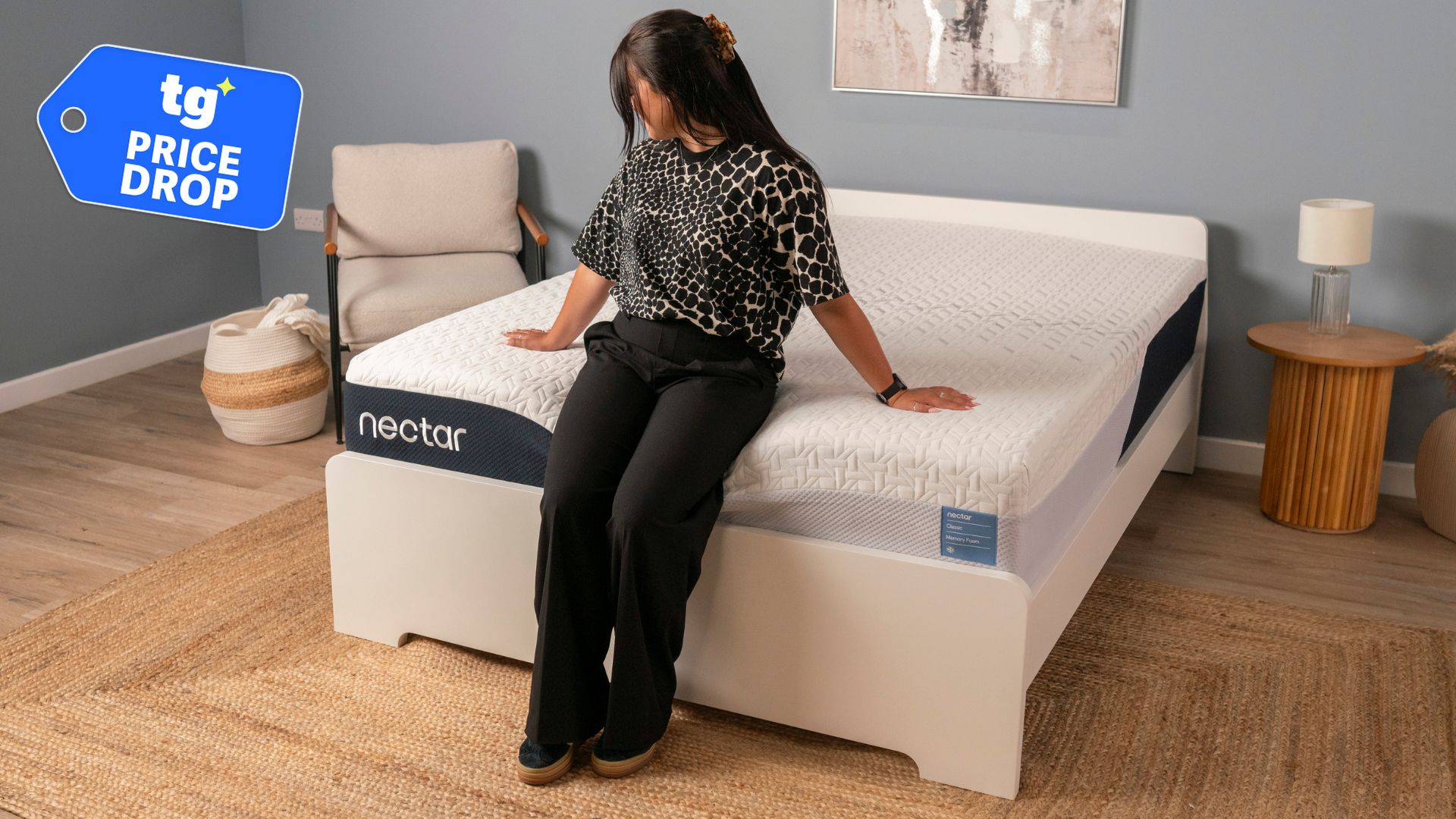 A woman sits on the edge of the Nectar Premier Memory Foam Mattress in a modern bedroom. 