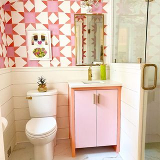Punchy small bathroom with cute two-tone vanity and co-ord graphic, pink patterned wallpaper