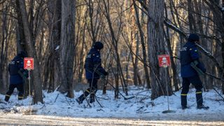 Ukrainian forces use metal detectors to look for mines during an urban combat training exercise within the Chernobyl exclusion zone in the abandoned city of Pripyat, Ukraine, on Feb. 4, 2022.