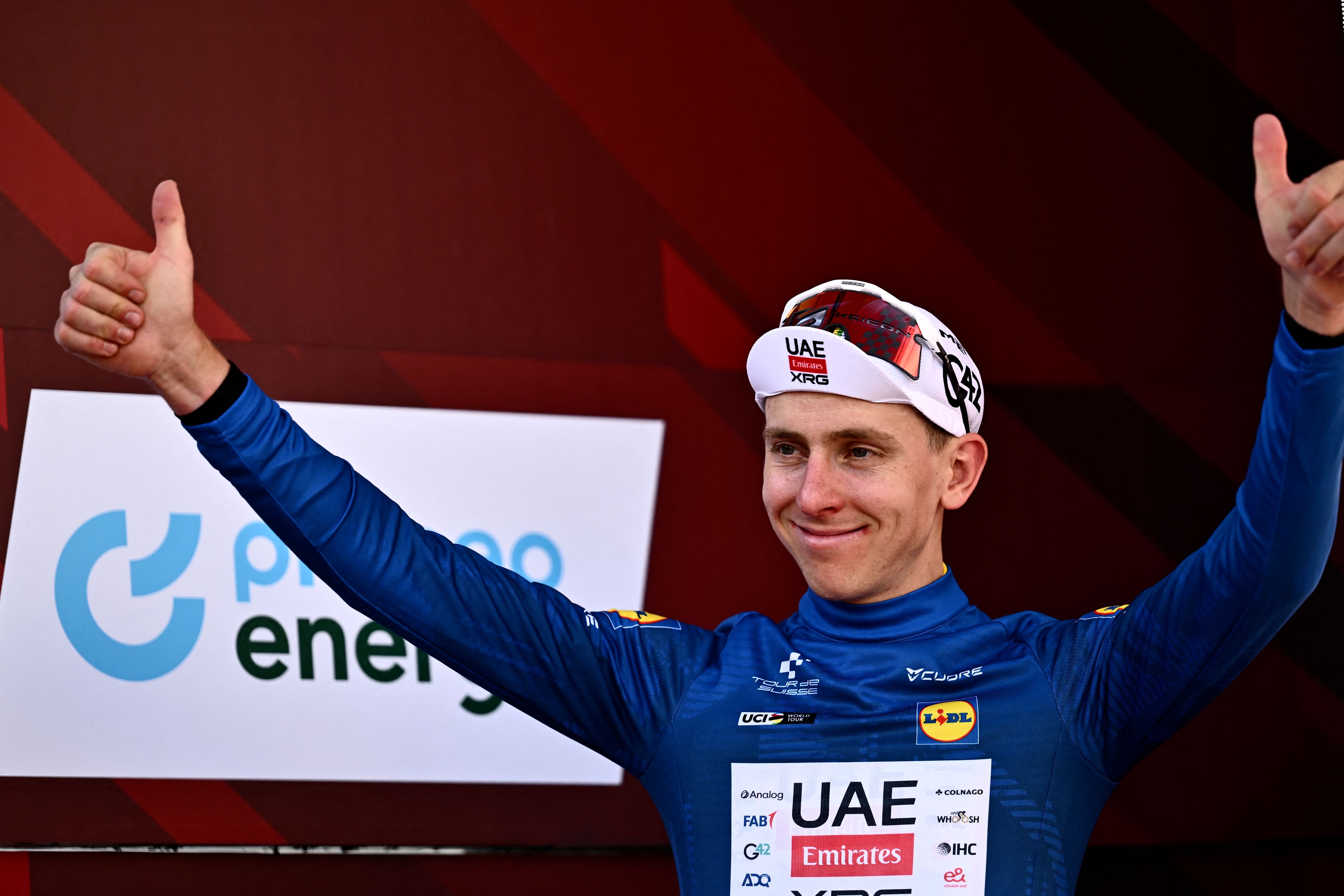 Slovenia's rider Tadej Pogacar of team UAE Emirates - XRG celebrates the Blue Jersey (Points Classification) on the podium of the first stage of the Men's Tour of Switzerland (Tour de Suisse) cycling race, in Sondrio, Italy, on June 17, 2026. (Photo by Marco BERTORELLO / AFP via Getty Images)