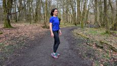 A runner on the trail wearing Teva Aventrail running sandals and a blue running top