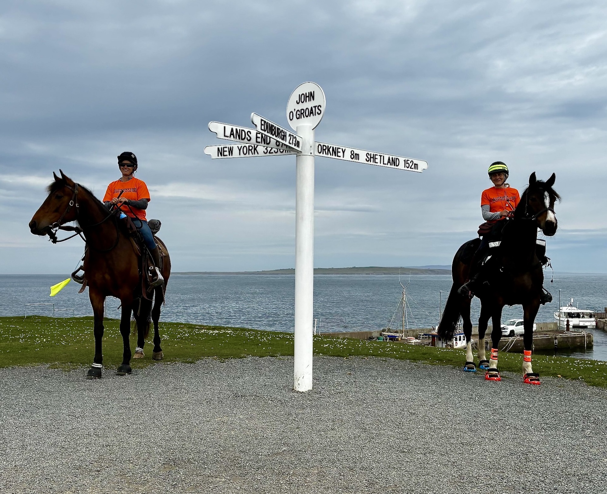 A rider and horse on each side of the John O'Groats sign