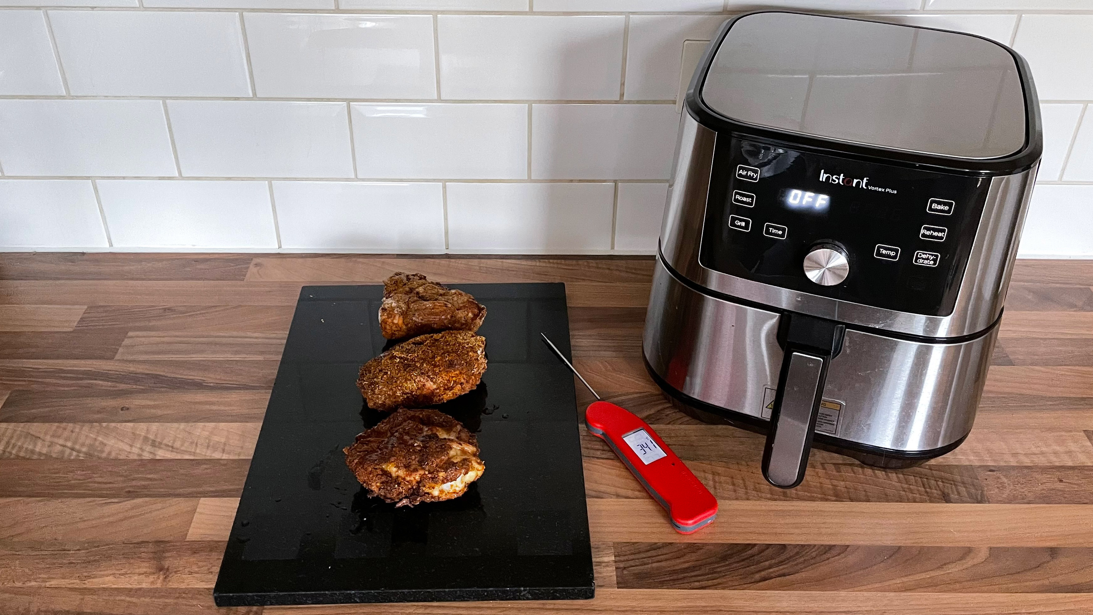 Healthy fried chicken thighs made with different coatings next to the Instant Vortex Plus air fryer they were made in