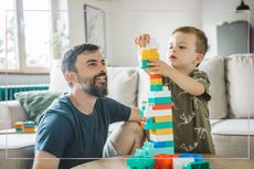 A father and son building a Lego tower together