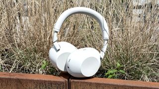 White Sony WH-1000XM6 noise-cancelling headphones outdoors in sunshine