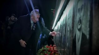 Mourners at a monument for Chernobyl victims in Chernobyl: Hour by Hour