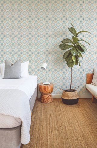 Peel and stick geometric bedroom wallpaper in natural bedroom with woven rug and house plant
