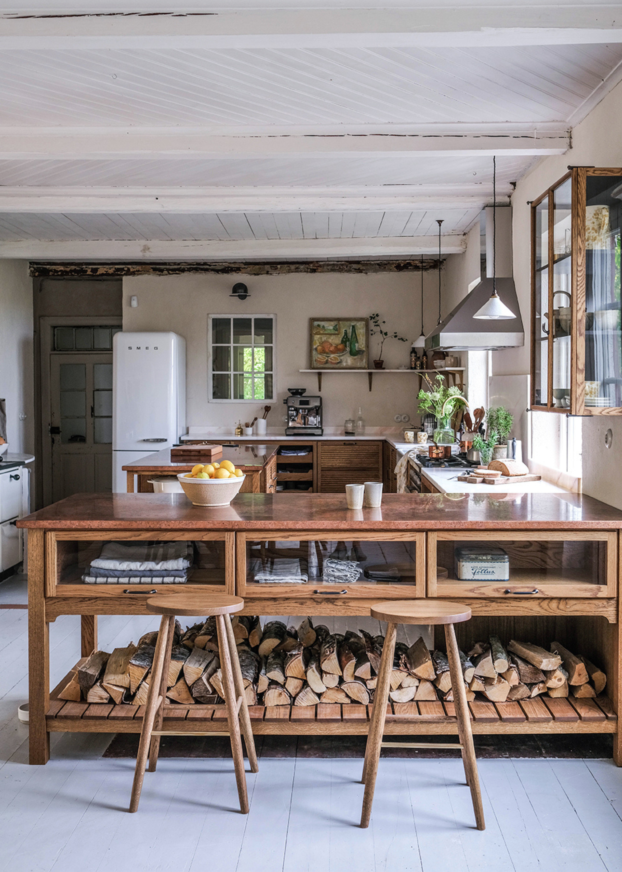 A kitchen peninsula made of wood with bar stools beside it