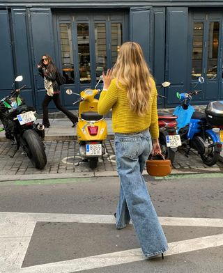 woman wearing baggy jeans and yellow cardigan