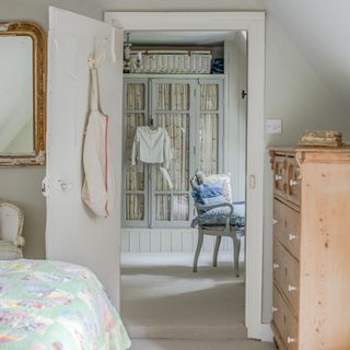 View through to dressing room with glass cabinet with fabric curtains