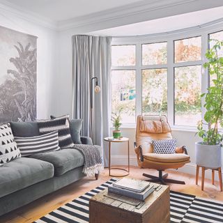 Living room with grey sofa and black and white stripe rug.