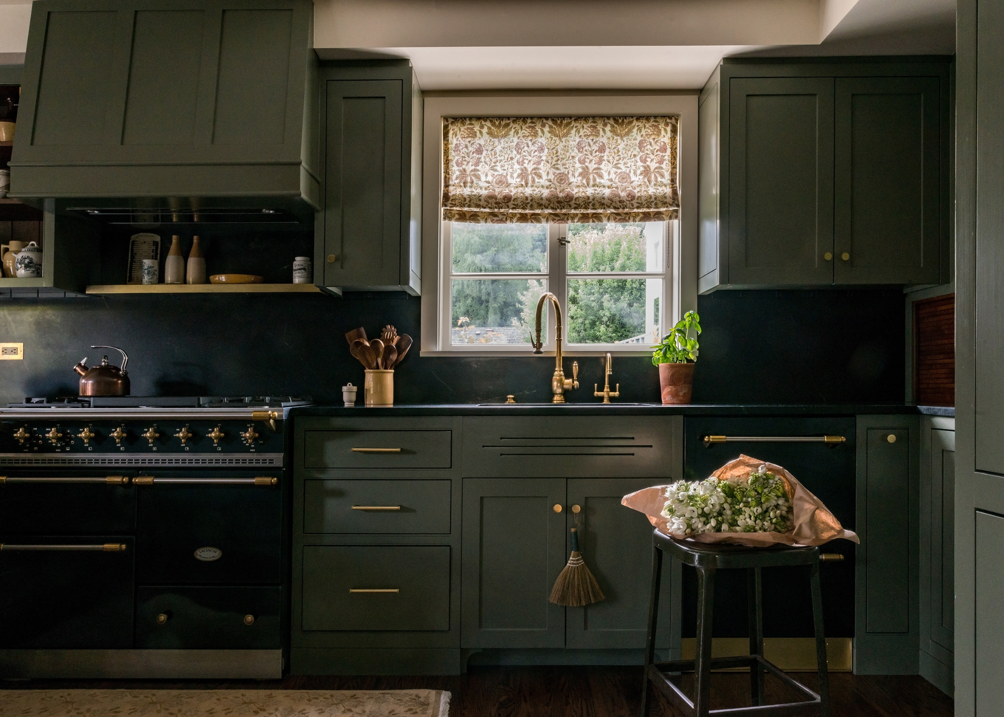 Green and gray colored kitchen with brass