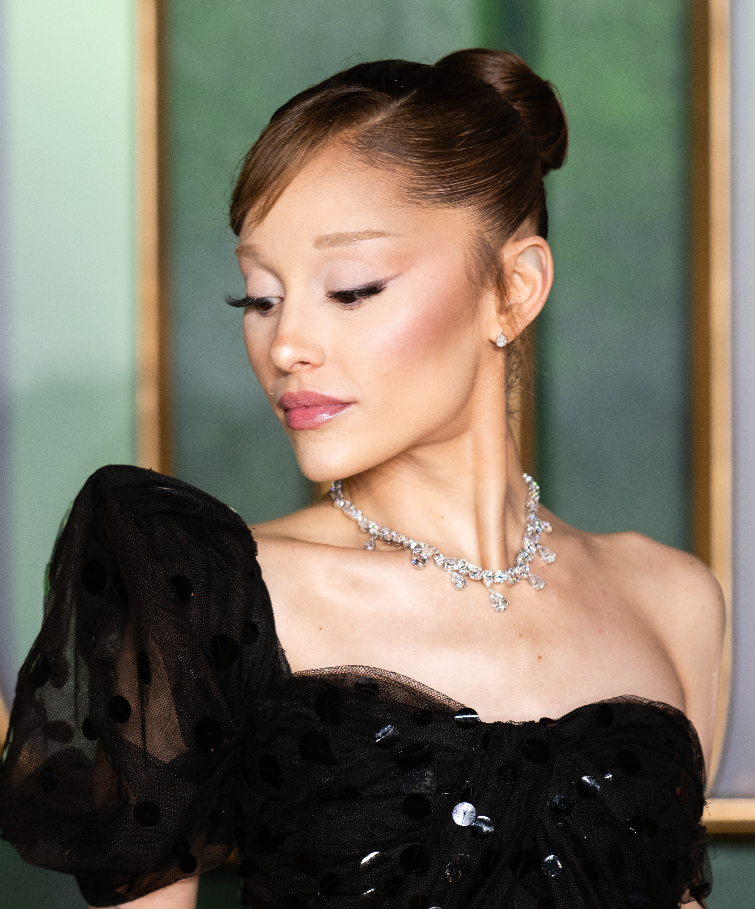 Ariana Grande in profile with a slicked-back bun