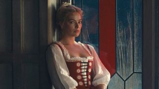 Margot Robbie sitting next to a window in Wuthering Heights