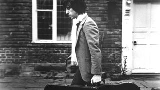 Jeff Beck walking with guitar case
