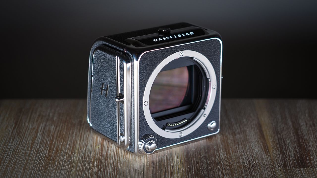 The Hasselblad 907X &amp; CFV 100C medium format camera with digital back, on a wooden table with artistic lighting
