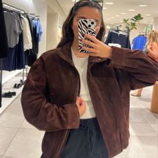 Woman wears brown suede jacket