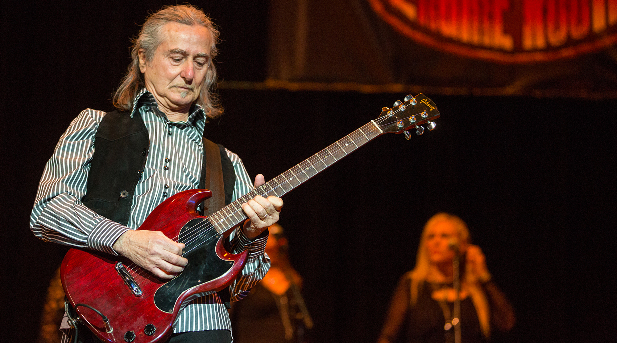 A photo of Barry Goudreau playing a Gibson SG onstage
