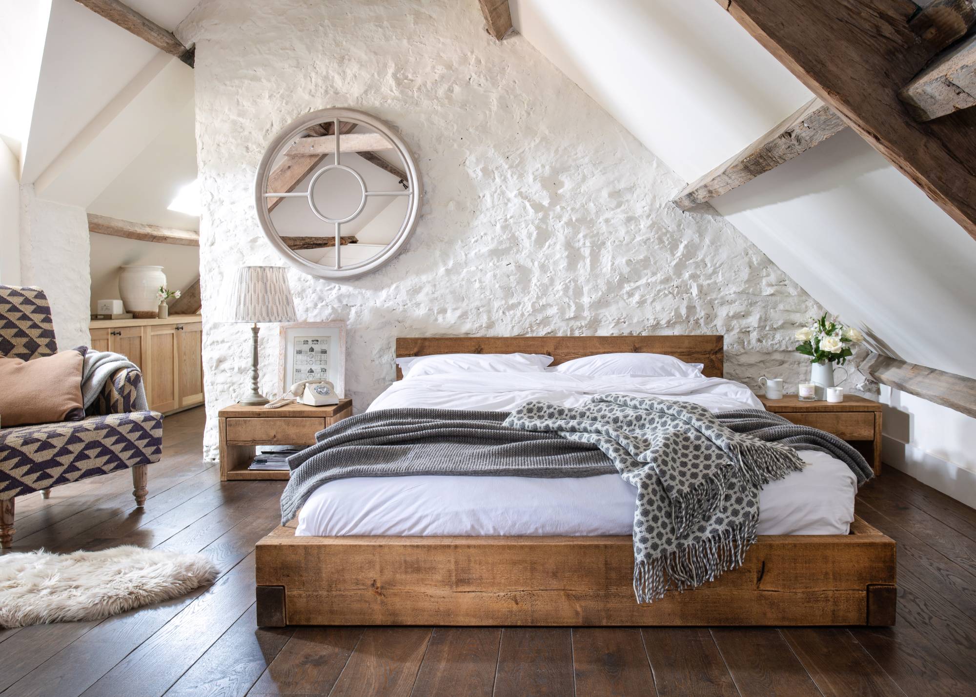 white cottage loft conversion bedroom with low bed and sloping eaves