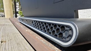 A dark grey Alienware m17 R5 gaming laptop sitting on a wooden table