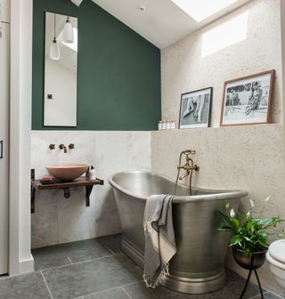 bathroom with cream and olive colour wall bathtub washbasin and stone flooring