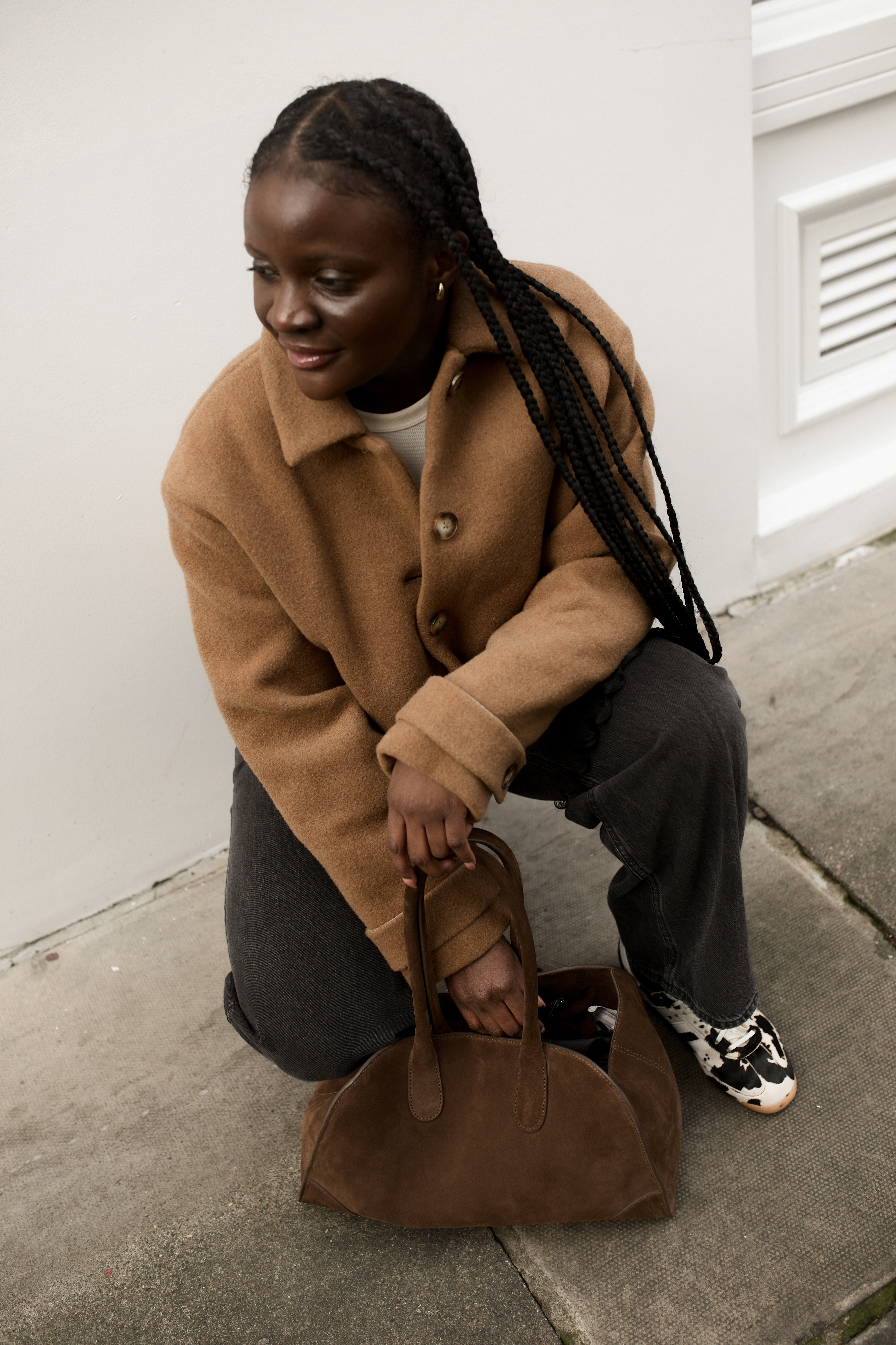 Brittany Davy wears cow print trainers with a wool jacket and jeans.