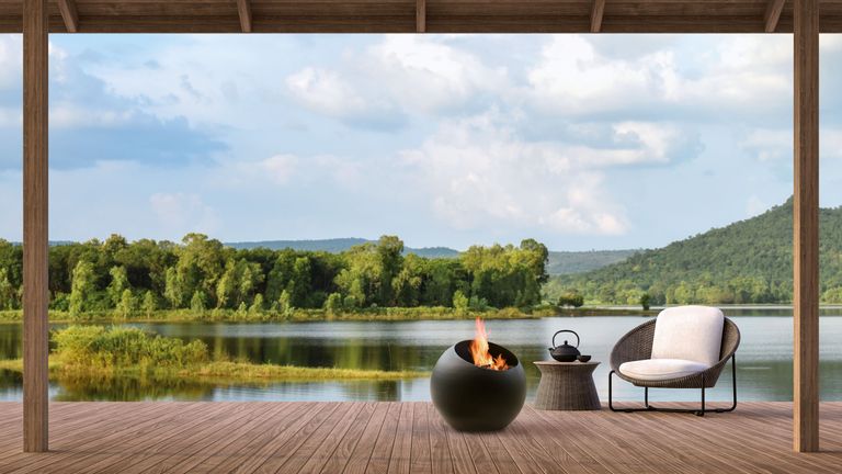 Outdoor fireplace ideas on decking against a beautiful lake and mountain backdrop.