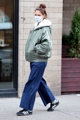 Katie Holmes wears a bomber jacket, nylon pants, and Adidas shoes.