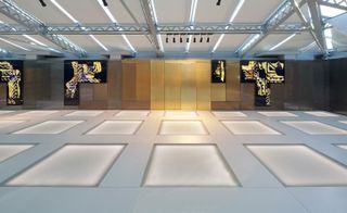 A glass pavilion featuring rectangle designs on grey flooring with geometric wall art.