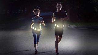 Two runners wearing Flipbelt Reflective running belts