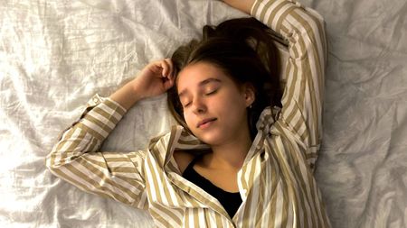 Woman sleeping in bed, sleep & wellness tips