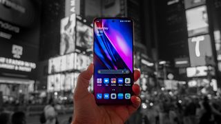 The OnePlus 10T standing out in color against a black & white backdrop of Times Square at night