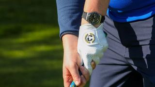 Someone gripping a golf club with a Duca Del Cosma Elte Pro Fontana Glove on