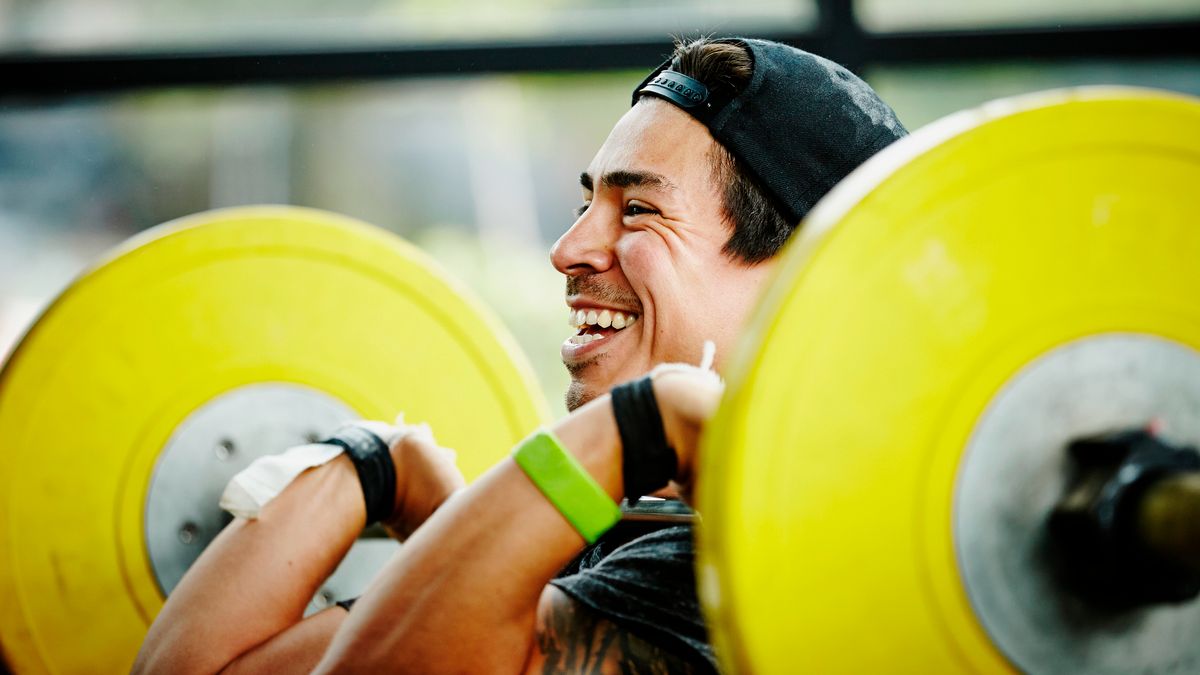 Man holding barbell across his chest in front rack position