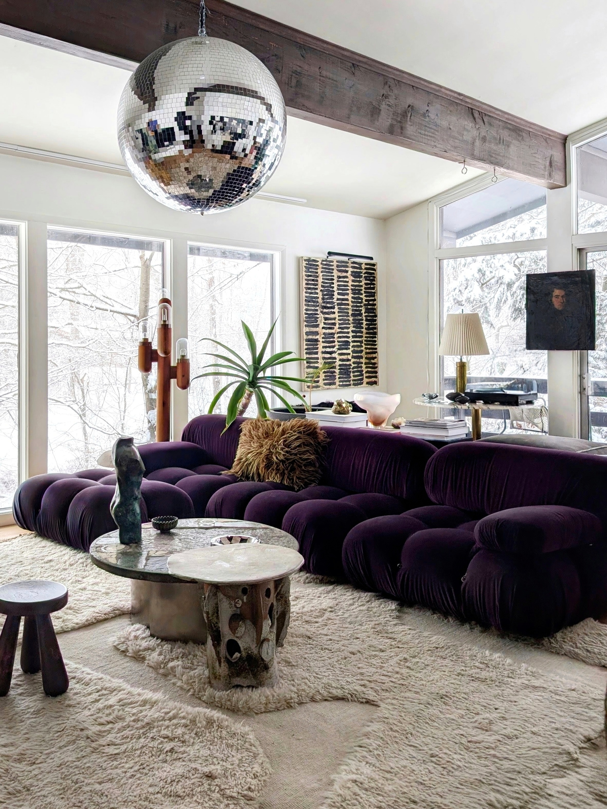 a living room with a purple sofa and a disco ball overhead