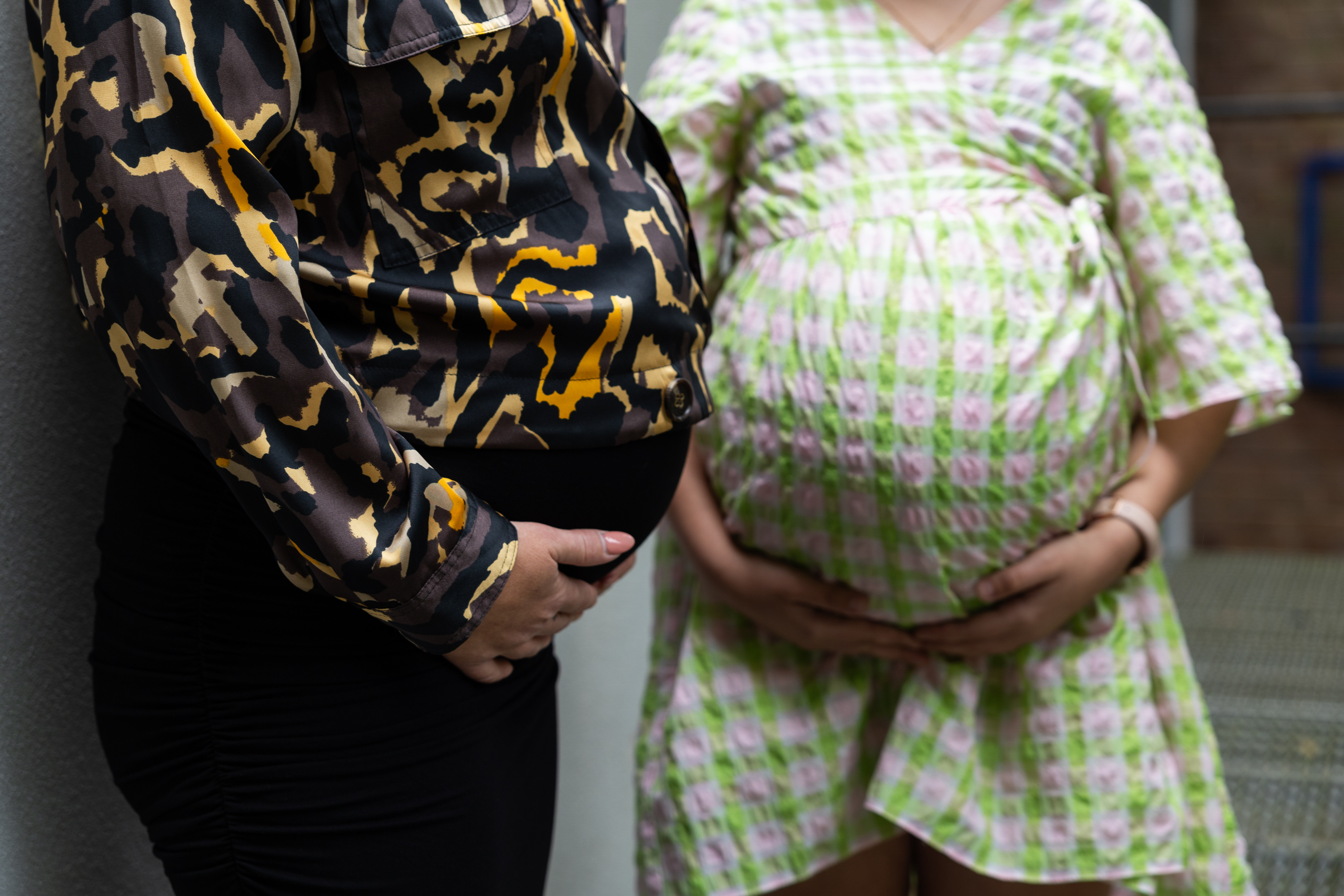 Two mystery women with pregnancy bumps.