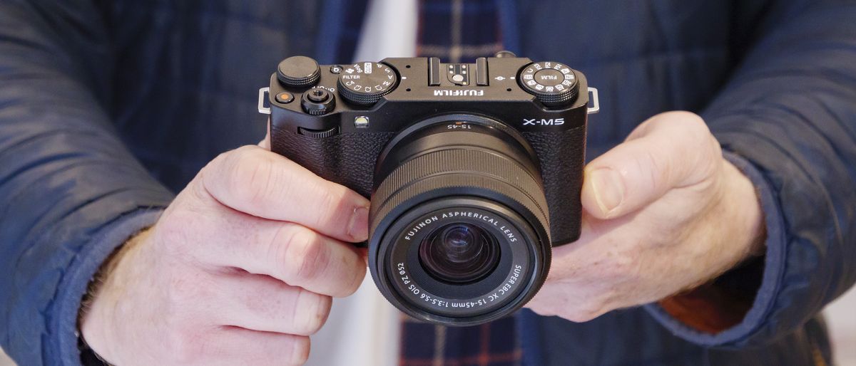 Fujifilm X-M5 camera with 15-45mm lens attached held by photographer