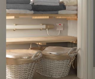 DIY airing cupboard with electric tubular heater and two wicker linen baskets