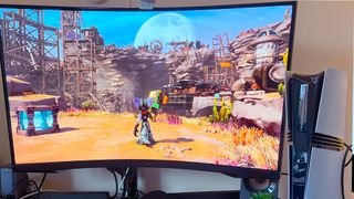 PS5 Pro next to monitor with Ratchet and Clank gameplay on screen